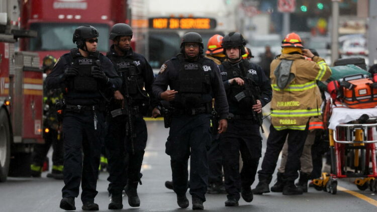 Police officers walk near the scene of a shooting at a subway station in the Brooklyn borough of New York City, New York, U.S., April 12, 2022. REUTERS/Brendan McDermid