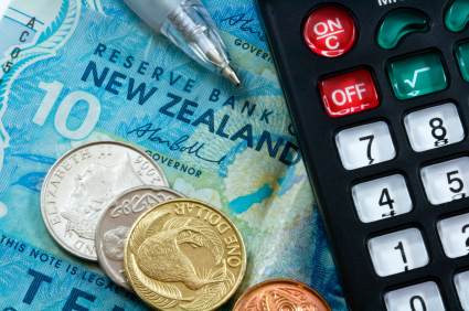 close up shot of calculator with pen and stack of coins on top of new zealand 10 dollar bills